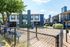 Charming apartment complex with modern design, spacious balconies, and a fenced courtyard surrounded by lush greenery.