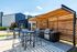 Inviting outdoor patio with modern barbecue grills and shaded seating, perfect for social gatherings.