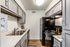 Sleek modern kitchen with stainless steel sink, black appliances, and gray cabinetry.