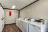 Contemporary apartment laundry room with multiple washing machines and dryers, offering convenience.