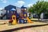 Colorful playground with slides and climbers located in a community apartment setting.