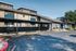 Inviting apartment building exterior with covered parking and lush greenery.
