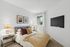 Inviting bedroom featuring elegant decor with contemporary artwork, plush bedding, and natural light from a window.