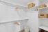 Modern and spacious walk-in closet with sleek shelving and wicker storage baskets.