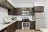 Modern kitchen with dark wood cabinets, stainless steel appliances, and white countertops.