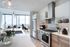 Elegant modern kitchen with stainless steel appliances, white cabinets, and a stunning city view through floor-to-ceiling windows.