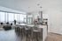 Sleek open-concept kitchen and living area with stunning city views, featuring modern appliances, chic pendant lighting, and elegant seating.