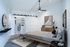 Elegant bedroom featuring a modern open closet, chic sliding barn door, and contemporary art, enhanced by stylish lighting and cozy decor.