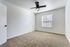 Bright, airy bedroom featuring plush carpet and a modern ceiling fan, perfect for creating a cozy retreat.