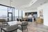 Elegant open-plan living and kitchen area with panoramic city views, sleek modern design, and stylish furnishings.