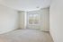 Bright, spacious room with plush carpet and large window overlooking a serene view. Perfect for a cozy retreat.