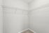Spacious, bright walk-in closet with wire shelving and plush carpeting, perfect for organized storage.