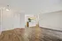 Modern open-concept living area with elegant wood flooring and a stylish kitchen, perfect for cozy gatherings.