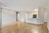 Spacious open-plan apartment showcasing sleek hardwood floors, modern kitchen with ample counter space, and minimalist design for comfortable living.