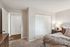 Inviting bedroom with plush carpet, cozy bed, stylish decor, and ample closet space showcasing modern comfort and elegance.