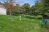 Vibrant outdoor dog park with benches, agility equipment, and lush greenery, perfect for a playful and active lifestyle.