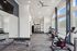 Modern apartment gym featuring bright windows, state-of-the-art exercise equipment, and open space for workouts.