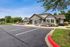 Charming residential clubhouse surrounded by vibrant landscaping and open parking, offering a welcoming community atmosphere.