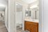 Bright apartment bathroom with modern fixtures, elegant vanity, and inviting hallway leading to an open living space.