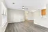 Bright and modern living area with sleek laminate flooring, contemporary ceiling fan, and open layout leading to a cozy kitchen.