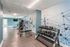 Modern fitness room with sleek equipment, vibrant geometric mural, and natural light.