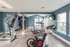 Bright and modern fitness center with cardio machines, weight racks, and large windows offering natural light.
