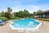 Inviting outdoor pool area with comfortable lounge chairs, lush greenery, and serene surroundings, perfect for relaxation and enjoyment.