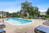 Inviting community pool area with comfortable lounge chairs and vibrant greenery, perfect for relaxation and social gatherings.