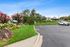 Inviting apartment complex entrance with vibrant landscaping and ample parking, showcasing welcoming community vibes.