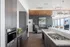 888 at Grand Hope Park Renovated Clubhouse Kitchen with Stainless Steel Appliances, Marble Countertops, and Ambient Lighting Opening in Seating Area