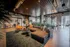 888 at Grand Hope Park Modern Open Living Room with Sleek Wooden Ceiling and Windows Offering Natural Lighting