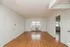 Bright and spacious living room with elegant hardwood flooring, large window, and fresh white walls creating a welcoming atmosphere.