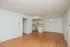 Bright and inviting open-concept apartment with elegant wood flooring, a compact yet modern kitchen, and stylish lighting fixtures.