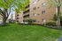 Charming apartment building with balconies, surrounded by lush greenery and vibrant landscaping, perfect for a tranquil lifestyle.