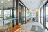 Elegant apartment lobby with modern leather seating, large windows, and vibrant botanical wallpaper offering a welcoming ambiance.