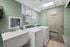 Bright and efficient laundry room featuring modern white washing machines, spacious utility sink, and green walls for a fresh ambiance.