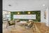 Chic apartment lobby with modern seating, plant wall, and elegant decor, creating a welcoming and stylish atmosphere.