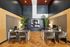 Modern office space with sleek desks, stylish chairs, and vibrant greenery under elegant lighting.