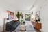 Contemporary living room with stylish decor, featuring a modern sofa, vibrant artwork, and abundant natural light from large windows.