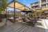 Luxurious outdoor lounge area with stylish seating and shaded lounge chairs, set amidst modern apartment buildings.