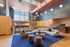 Spacious modern living area with high ceilings, stylish lighting, and cozy seating, featuring a luxurious lounge setting with artistic wall art and large windows.
