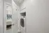 Bright hallway featuring a modern in-unit washer and dryer with a cozy bedroom view, showcasing functional space and stylish convenience.
