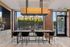 Chic dining area with modern lighting, large windows overlooking a cozy outdoor patio, and stylish brick accents.