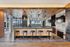 Chic modern kitchen with industrial accents, featuring wooden ceiling, elegant pendant lighting, and stunning waterfront view.