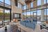 Luxurious modern lounge with floor-to-ceiling windows offering stunning waterfront views, cozy seating, and elegant decor.