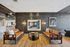 Chic modern lounge with warm leather sofas, sleek wood floors, and a stylish wall mirror reflecting a cozy meeting area.