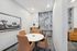 Chic meeting room with stylish leather chairs, round table, modern art, and elegant lighting.