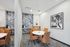 Chic and modern meeting room with stylish leather chairs, artistic wallpaper, and elegant lighting.