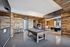 Chic modern entertainment room featuring a rustic pool table, vintage arcade machine, and stylish dining area with wood accents.