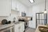 Modern kitchen with sleek white cabinetry, stainless steel appliances, and elegant granite countertops.